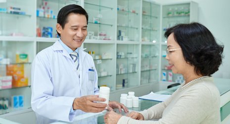 Pharmacist handing out prescription medicine